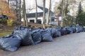 Many green garbage bags at curb