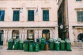 Many green garbage cans. Removal of garbage early in the morning