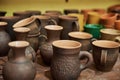 Many handmade clay jugs on shelf in workshop