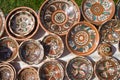 Many handmade and handpainted ceramic clay plates with floral and abstract pattern