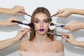 Many hands apply makeup on woman face Royalty Free Stock Photo