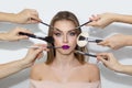 Many hands apply makeup on woman face Royalty Free Stock Photo