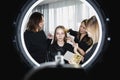 Many hands applying make-up to beautiful young woman in beauty salon Royalty Free Stock Photo