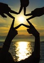 Many hands connecting to star shape at sunset, Teamwork Concept