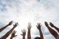 Many hands raised up against the blue sky. Friendship