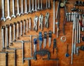 Many handymen, industrial or hand tools hanging on brown wooden background in garage for fixing and maintenance vehicle