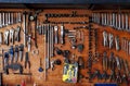 Many handymen, industrial or hand tools hanging on brown wooden background in garage for fixing