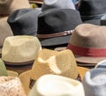 Many hats for men in different shapes and colors in one display for sale