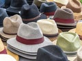 Many hats for men in different shapes and colors in one display for sale