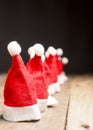 Hats of Santa in a row on rustic wood Royalty Free Stock Photo