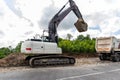 Many heavy heavy industrial road construction machinery on new highway road construction site sunny day with blue sky Royalty Free Stock Photo