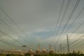 Many high voltage power pole and cable lines with smokestack of power plant in back with beautiful sky near evening Royalty Free Stock Photo