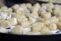 Many homemade gnocchi on a tray