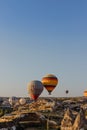 Many hot air balloons fly in sky at dawn