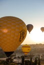 Many hot air balloons fly in sky at dawn