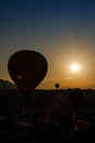 Many hot air balloons fly in sky at dawn