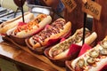 Many hot dogs with various toppings and sauces. Grilled hot dog sausage in a fresh bun. Spicy hot dog with jalapeno, hot dog with