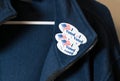 Many I Voted stickers on blue jacket hung on hanger