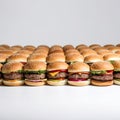 Many identical delicious cheeseburgers, hamburgers, burgers, sandwiches next to each other on white