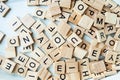 Many identical wooden and square letters on a light background