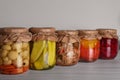 Many jars with preserved vegetables on white wooden table Royalty Free Stock Photo