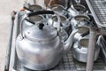 Many kettles of aluminum on sieve rack.