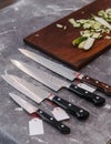 Many kinds of super sharp Japanese kitchen knives with ultra thin slice zucchini on wooden chopping board Royalty Free Stock Photo