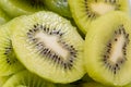 Many kiwi slices are placed in a glass crisper. Kiwifruit slices without peel