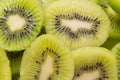 Many kiwi slices are placed in a glass crisper. Kiwifruit slices without peel