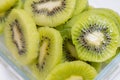 Many kiwi slices are placed in a glass crisper. Kiwifruit slices without peel