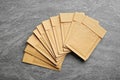 Many kraft paper envelopes on grey background, flat lay