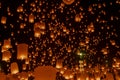 Many lanterns float in the night sky.