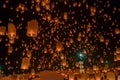 Many lanterns float in the night sky.