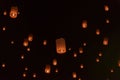 Many lanterns float in the night sky.