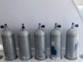 Many large metal, aluminum oxygen cylinders for breathing and diving stand on special stands on board a boat, ship, cruise liner,