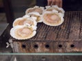 Many large scallops roast on the stove to sale for customer at Kuromon market.Scallops are a popular food among tourists visiting