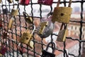 Many locks without keys hangs a fence near the castle hill in the background of the city of Graz, Austria. Locks left by people in