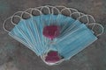 Many medical blue face masks to protect against coronavirus COVID-19. Hourglass on top of medical disposable masks. Time stopped