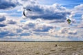 Many men in the water between the waves. Kitesurfing Kiteboarding action on the sea Royalty Free Stock Photo