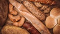 Many mixed baked breads and rolls on rustic wooden table Royalty Free Stock Photo