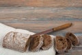 Many mixed breads and rolls of baked bread on wooden table background.