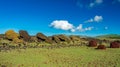 Many moai statues and pukao on the ground
