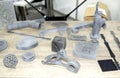 Many models printed on 3D printer. Gray and black objects printed 3D printer.