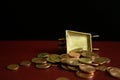 Coins falling from a golden vintage wheelbarrow.