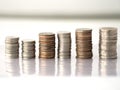 Many money coins are stacked orderly reflection on the ground with white background Royalty Free Stock Photo
