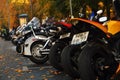 Many motorbikes stand in a row.