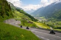 Many motorcycles racing down the curvy Klausenpass mountain road in the Swiss Alps near Glarus