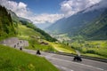 Many motorcycles racing down the curvy Klausenpass mountain road in the Swiss Alps near Glarus