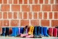 Many muddy colored wellies on the ground