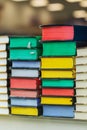 Many multi-colored books are stacked on top of each other in the glass showcase of a bookstore. Collection of old books